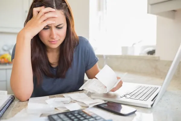 Donald Trump child support 2025: a custodial parent going through unpaid bills at a table