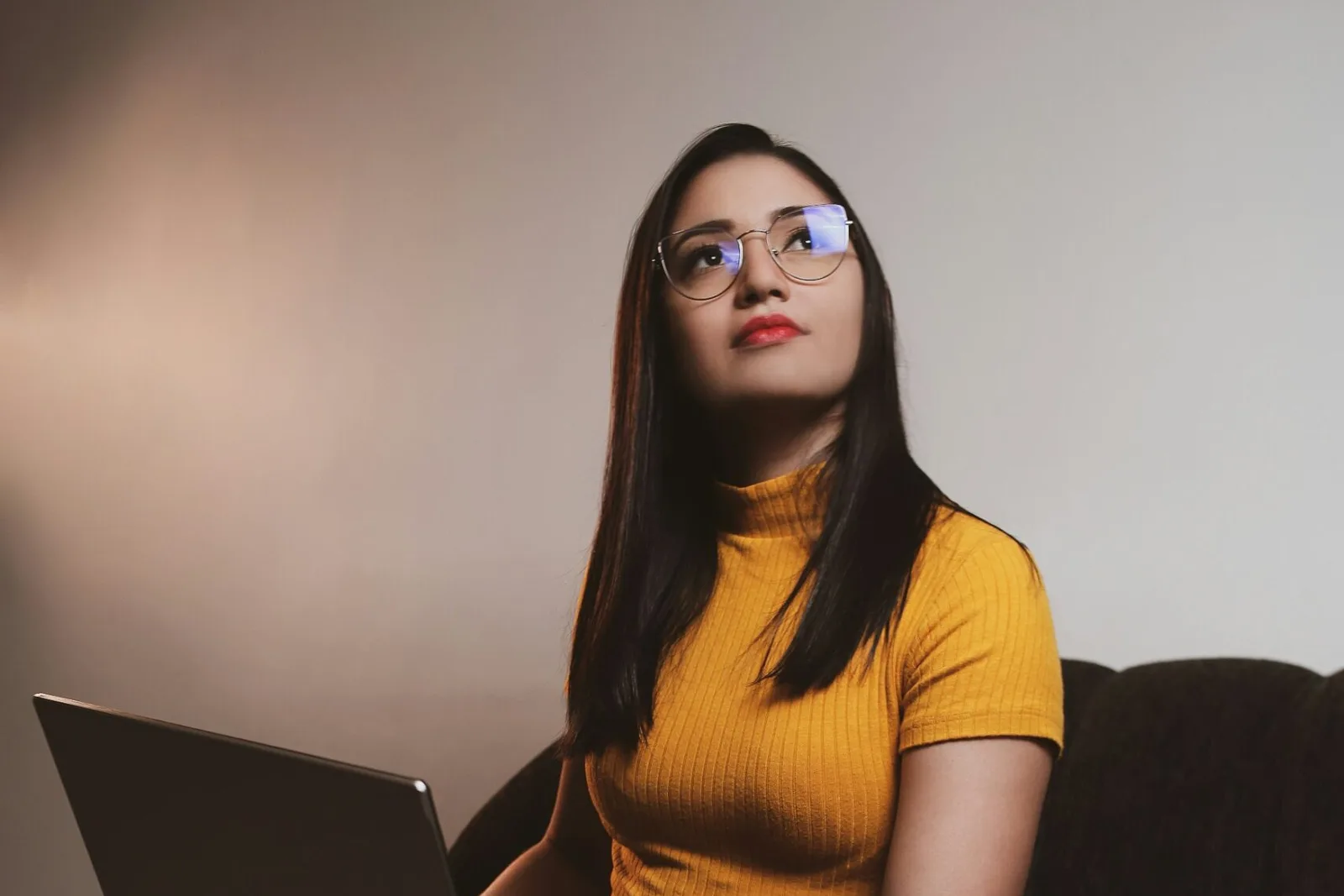 Can I volunteer remotely: a young woman with glasses working on a laptop at home